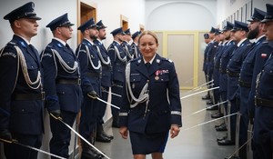Zdjęcie: policjantka idzie, obok niej policjanci z szablami.