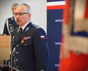 Zdjęcie: policjant przemawia do mikrofonu.