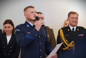 Zdjęcie: policjant mówi do mikrofonu.