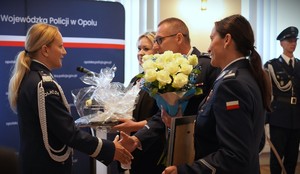 Zdjęcie: policjantka przyjmuje kwiaty.