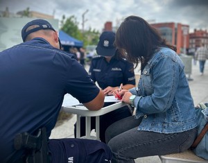 policjanci i kobieta podczas wypisywania formularzy
