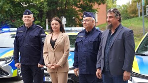 Zdjęcie: kobieta, obok niej policjanci i mężczyzna w marynarce.