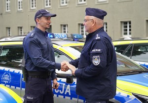 Zdjęcie: policjant wręcza klucze policjantowi.
