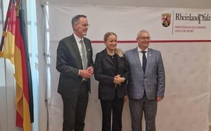 Trzy osoby uśmiechają się do zdjęcia.