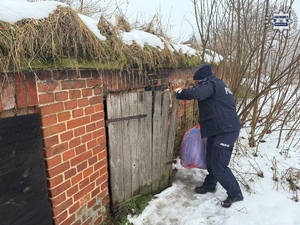 zdjęcie: policjant sprawdzający komórki, w których przebywają bezdomni