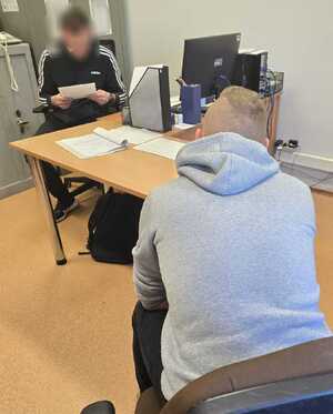 zdjęcie: policjant z zatrzymanym mężczyzną