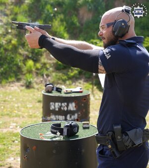 policjant podczas turnieju strzeleckiego