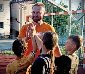policjant w czasie wolnym trenuje koszykówkę z dziećmi