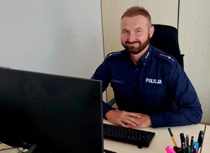 policjant podczas pracy za biurkiem