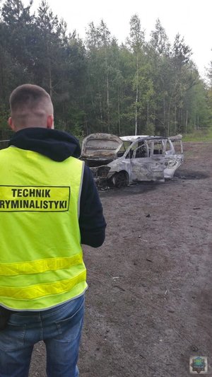 Policjanci pracujący na miejscu pożaru pojazdu