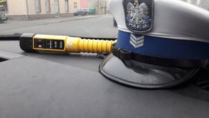 czapka policjanta ruchu drogowego i alkoblow na podszybiu radiowozu