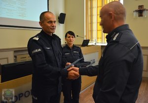 komendant gratuluje nagrodzonemu policjantowi