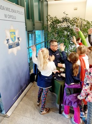 dzieci zgromadzone przez stoiskiem profilaktycznym KMP Opole
