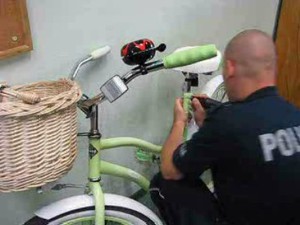 policjant kuca przy rowerze