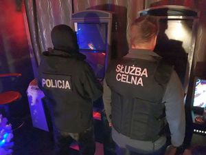policjant oraz funkcjonariusz służby celno-skarbowej zabezpieczają automaty do gier