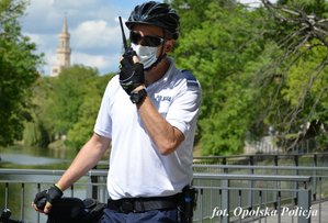 policjant z drużynki rowerowej trzyma radiostację w dłoni