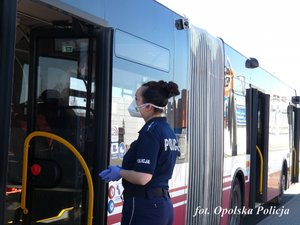 policjantka stoi obok autobusu MZK