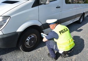 policjant sprawdza koła pojazdu