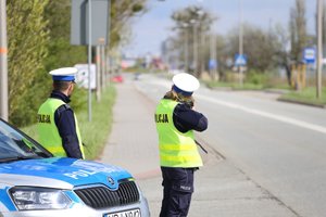 policjanci przy drodze mierzą prędkość kierowców