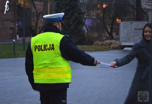 policjant wręcza odblask kobiecie