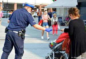 policjant ruchu drogowego na mieście wręcza odblask kobiecie