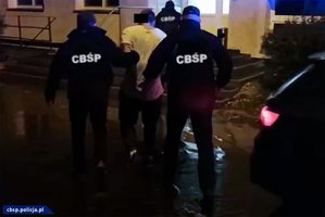 policjanci z CBŚP prowadzą zatrzymanego mężczyznę