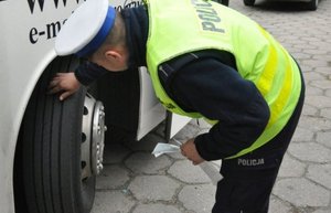 policjant sprawdza ogumienie w autokarze