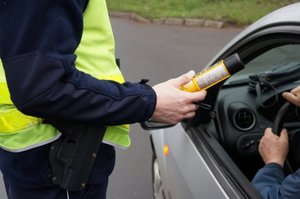 policjant przeprowadza badanie alkoblowem