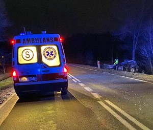 ambulans stoi na drodze w prawym rogu rozbity samochód obok policjant