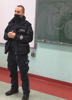 policjant stoi przy tablicy