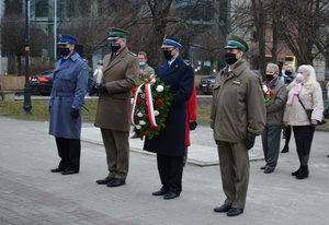 komendant Basik obok przedstawicieli innych służ mundurowych składa kwiaty pod pominikiem