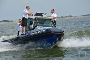 łódź policyjna płynie jeziorem na niej 3 policjanci