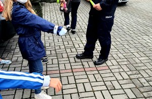 policjant zakłada dzieciom odblaski